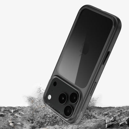 Coque ONE bumper pour iPhone 18 Pro et Pro Max sur un téléphone noir, illustration d’une chute sur un sol rocheux