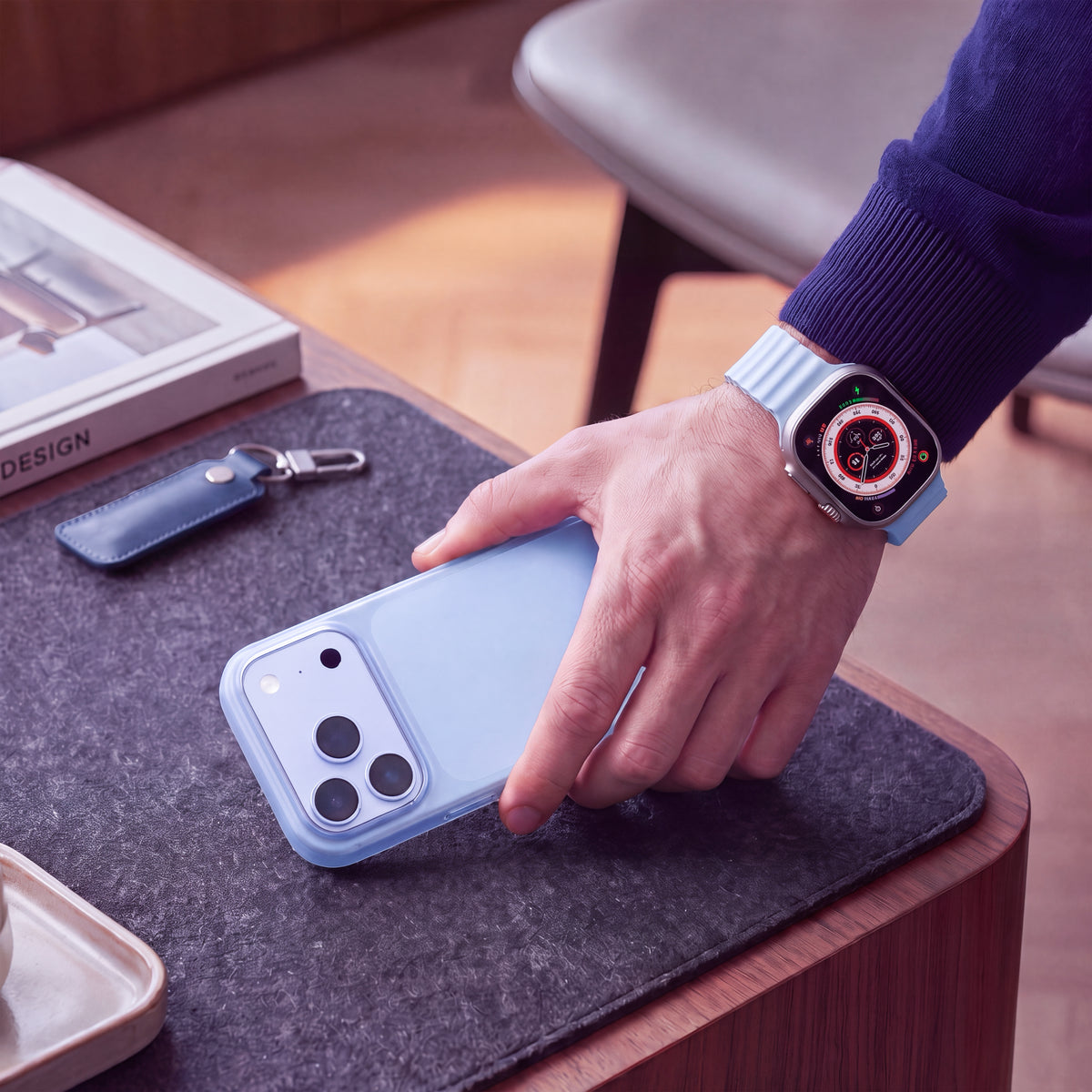 Une main saisit un iPhone en coque ORIGINAL Glacier sur une table